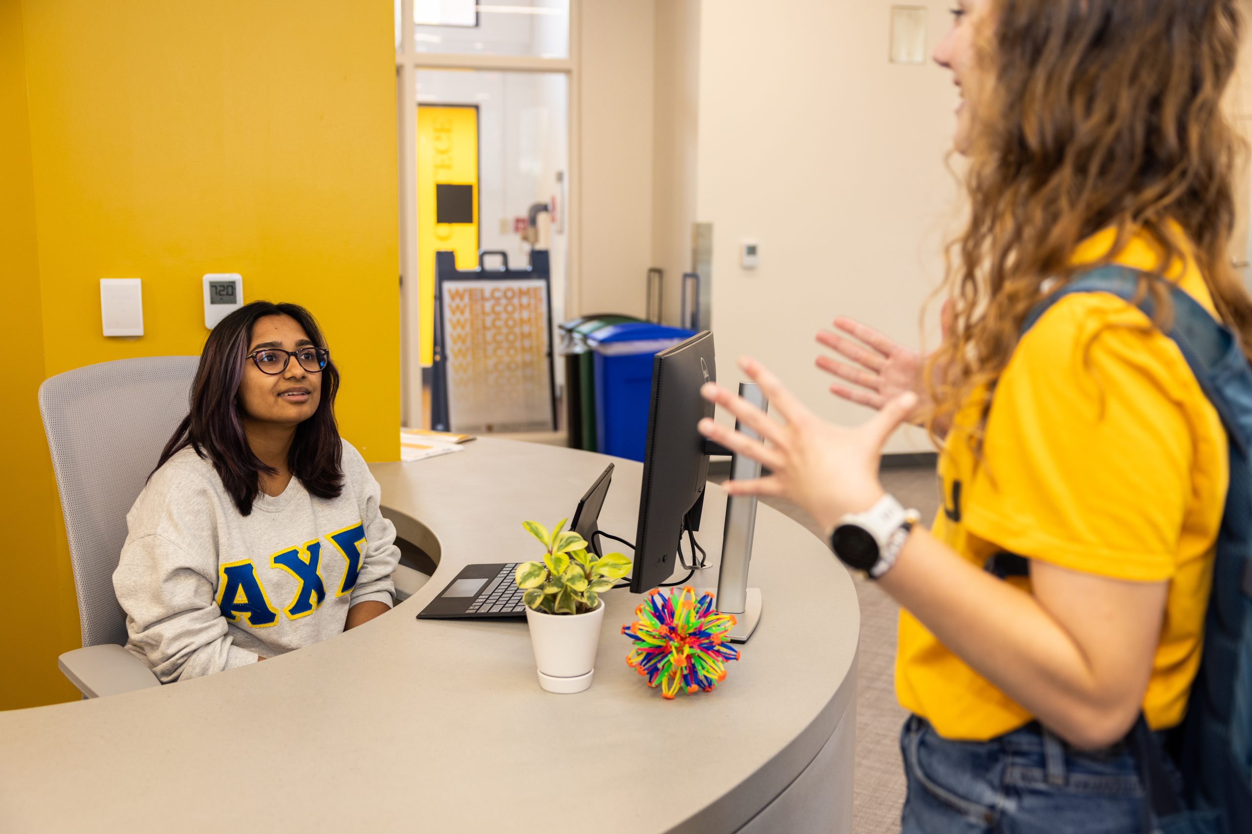 Two students talk over a counter