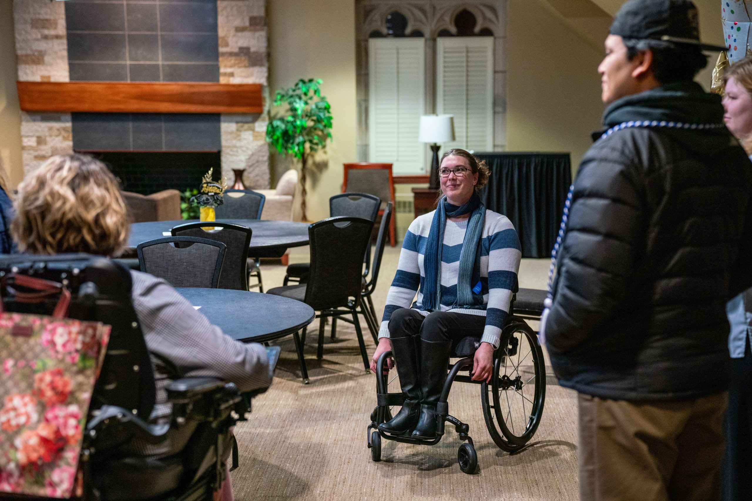A student in a wheel chair talks to other students at the Disability Center graduation