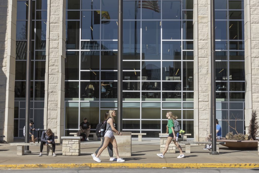 People sit and walk outside the MU Student Center at the University of Missouri