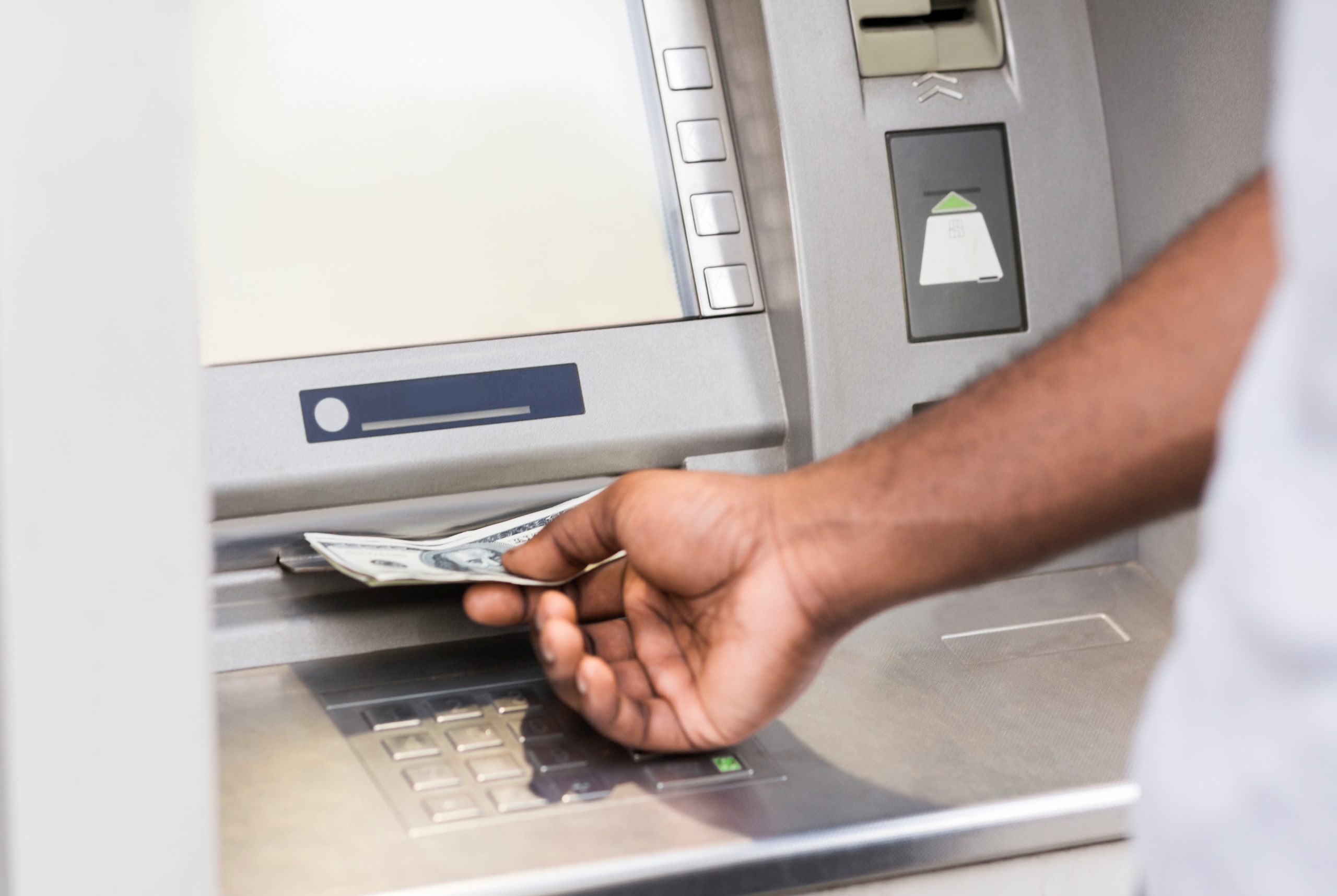 A person retrieves money from an ATM