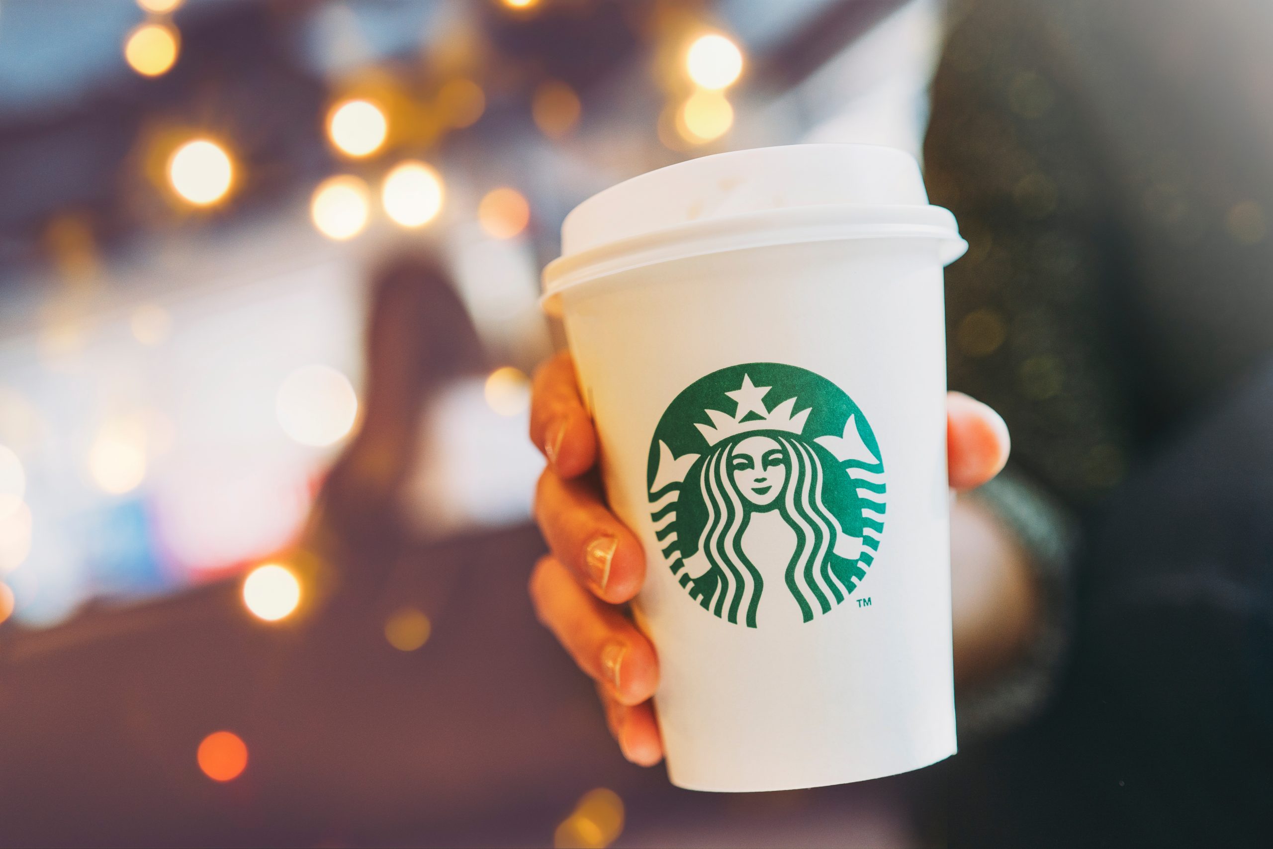 A hand holding a Starbucks cup