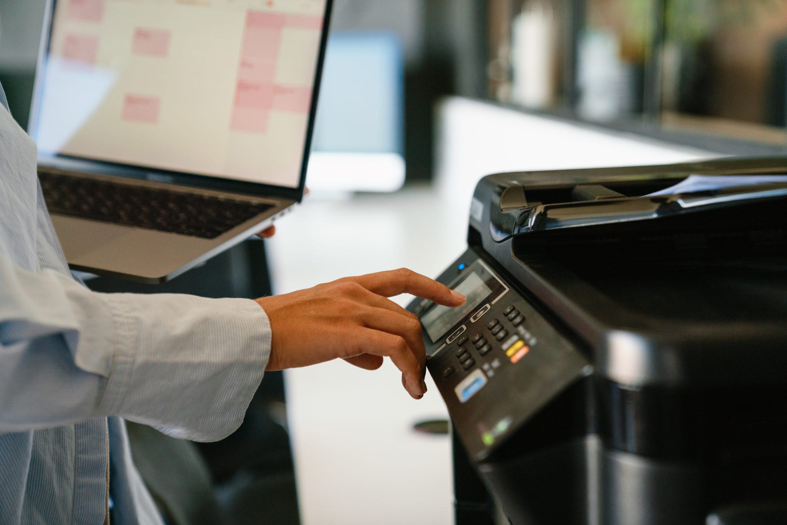 A person clicking buttons on a printer