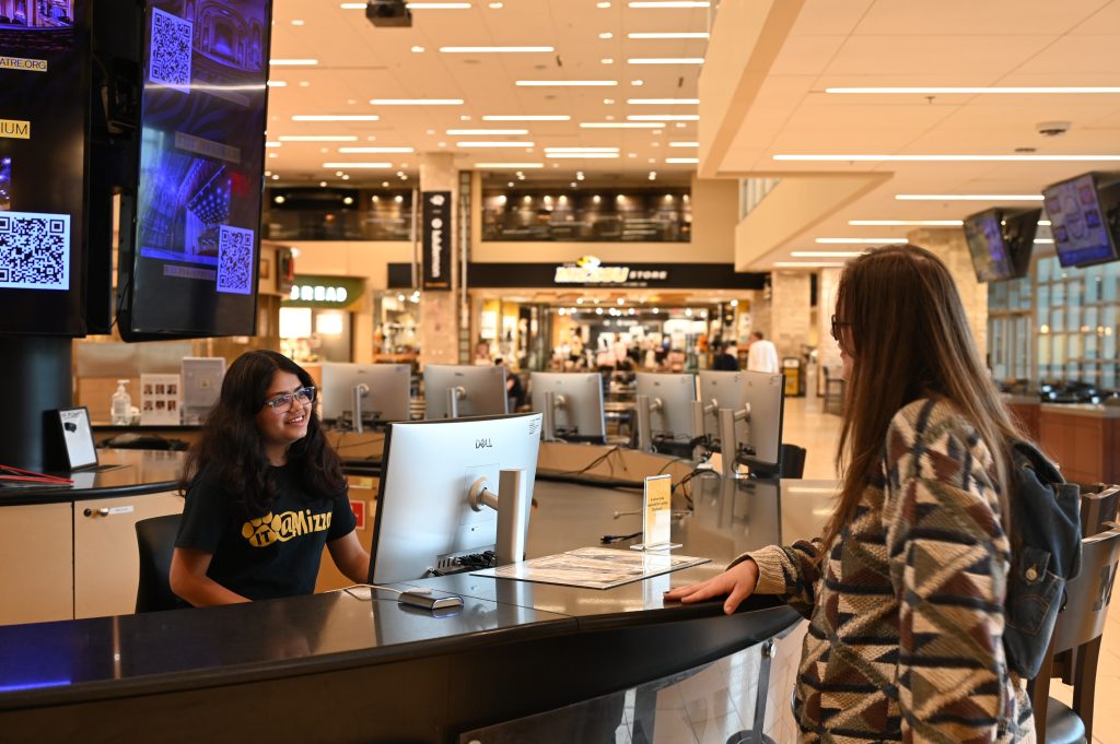A student asks for help at the Information Desk in the MU Student Center