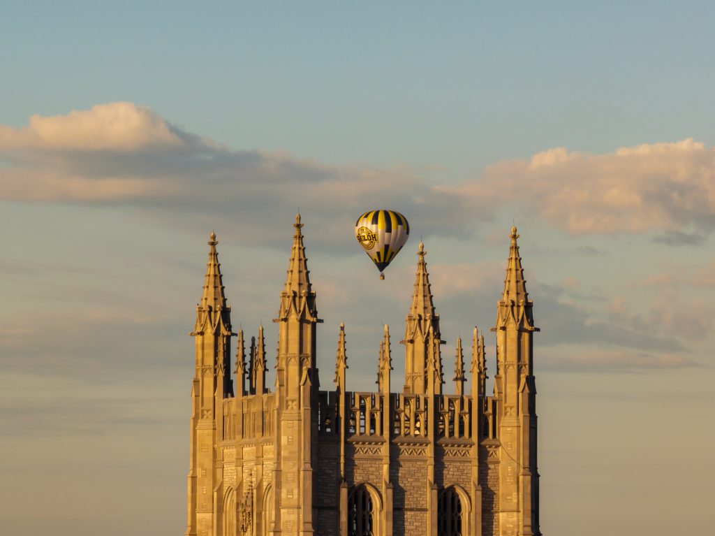 A hot air balloon glides above the Memorial Student Union Tower